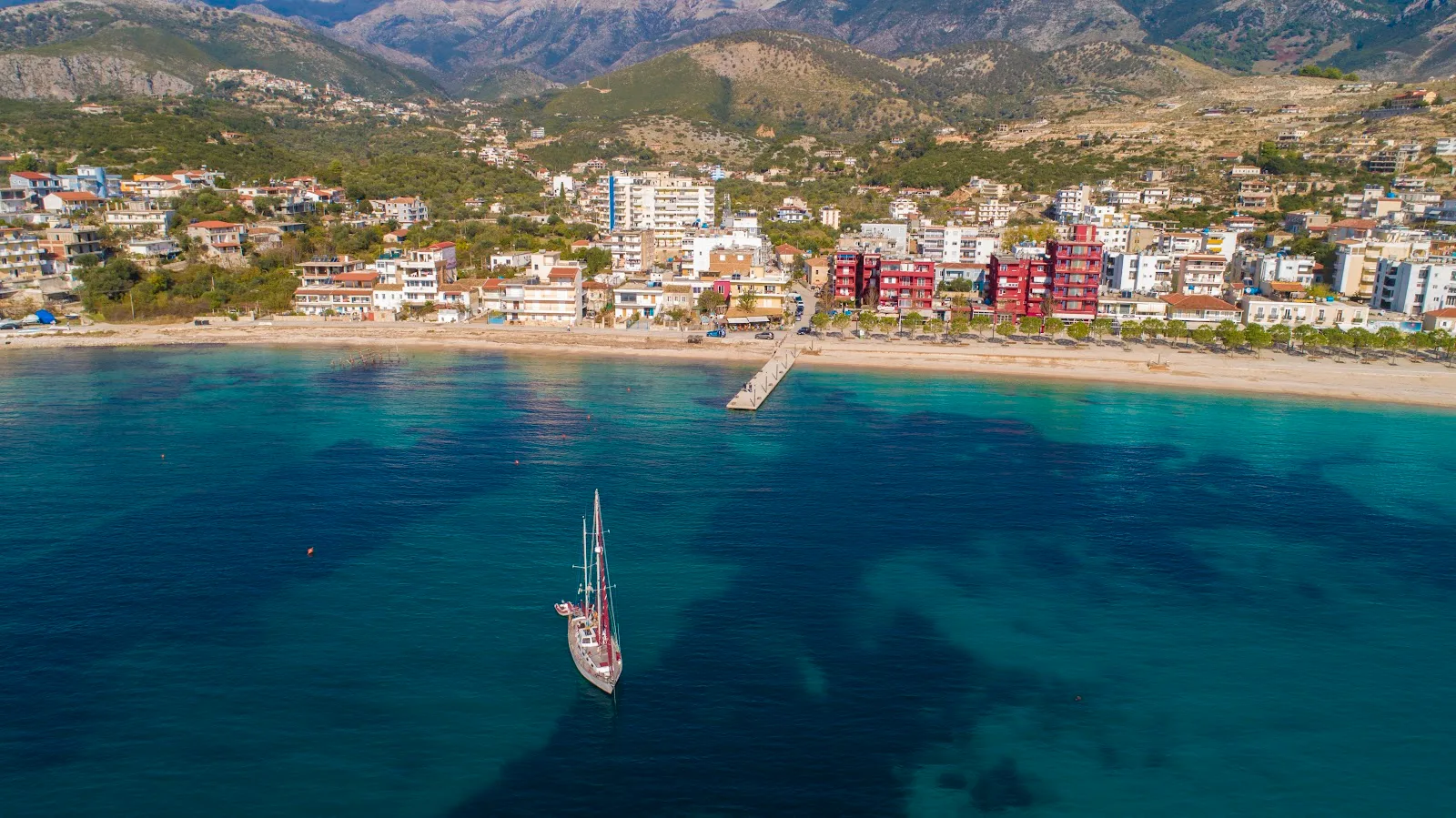 Stone breakwater and fishing boats at Himara Mini Dock