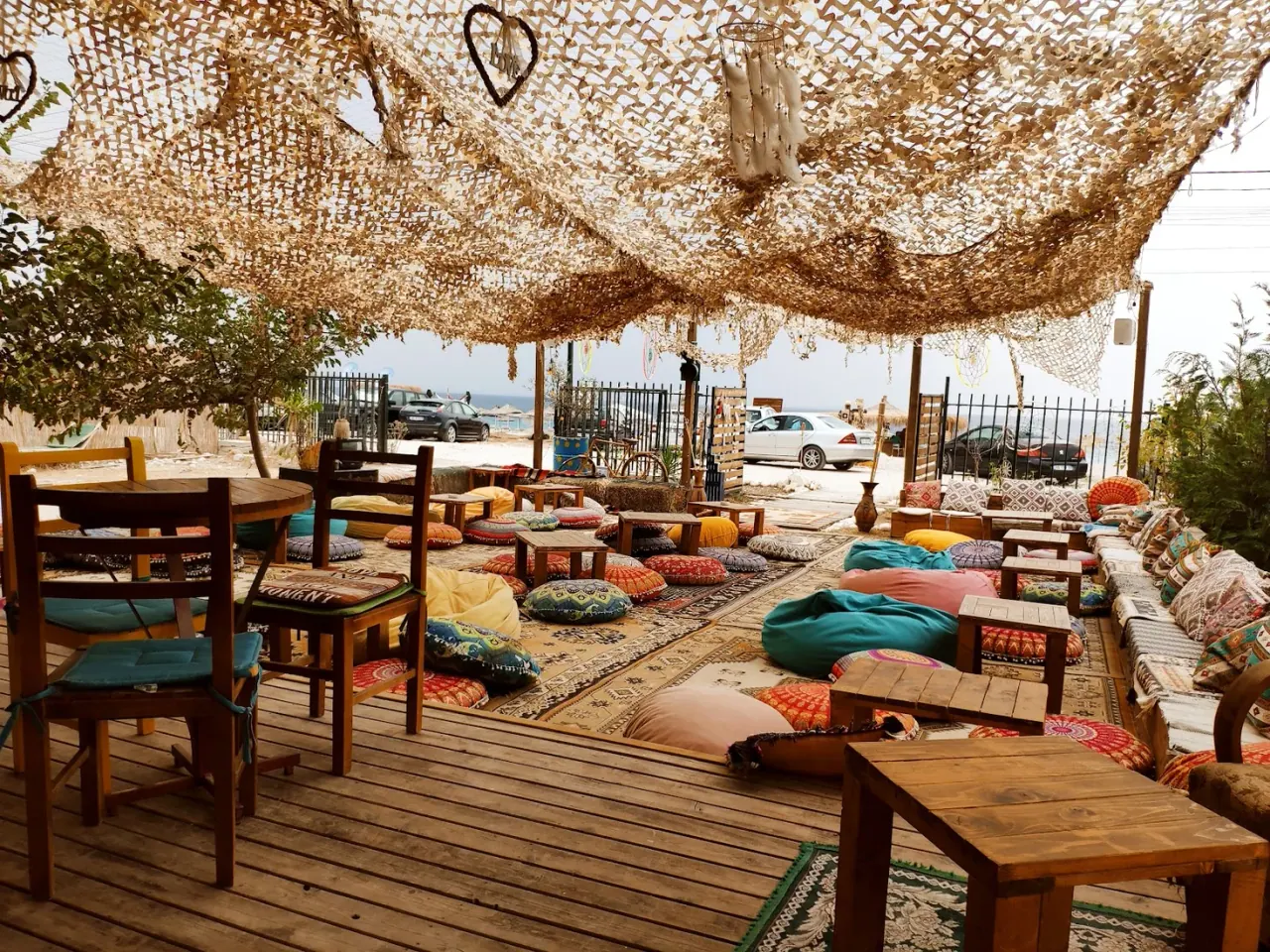 BOHO Livadh beach bar's boho-chic lounge with floor cushions, rugs and a fishing-net canopy by the sea
