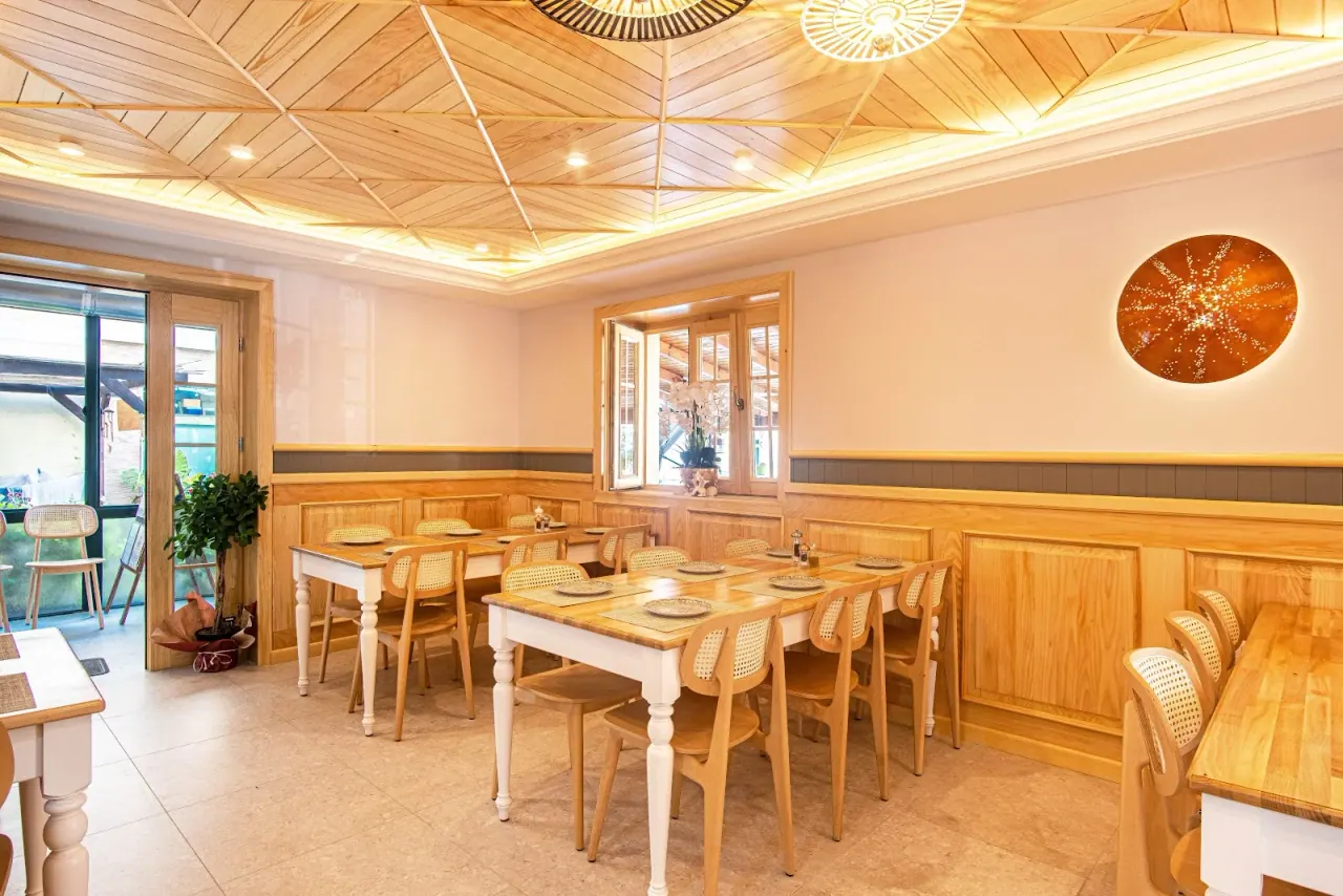 Warm wood-panelled dining room with set tables at Taverna Lefteri in Himara
