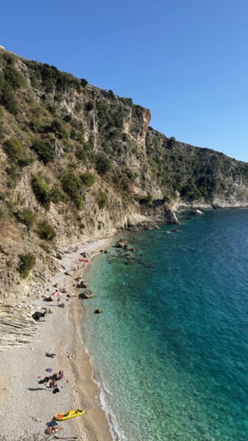 Hidden cove at Filikuri Beach with crystal-clear turquoise water surrounded by cliffs