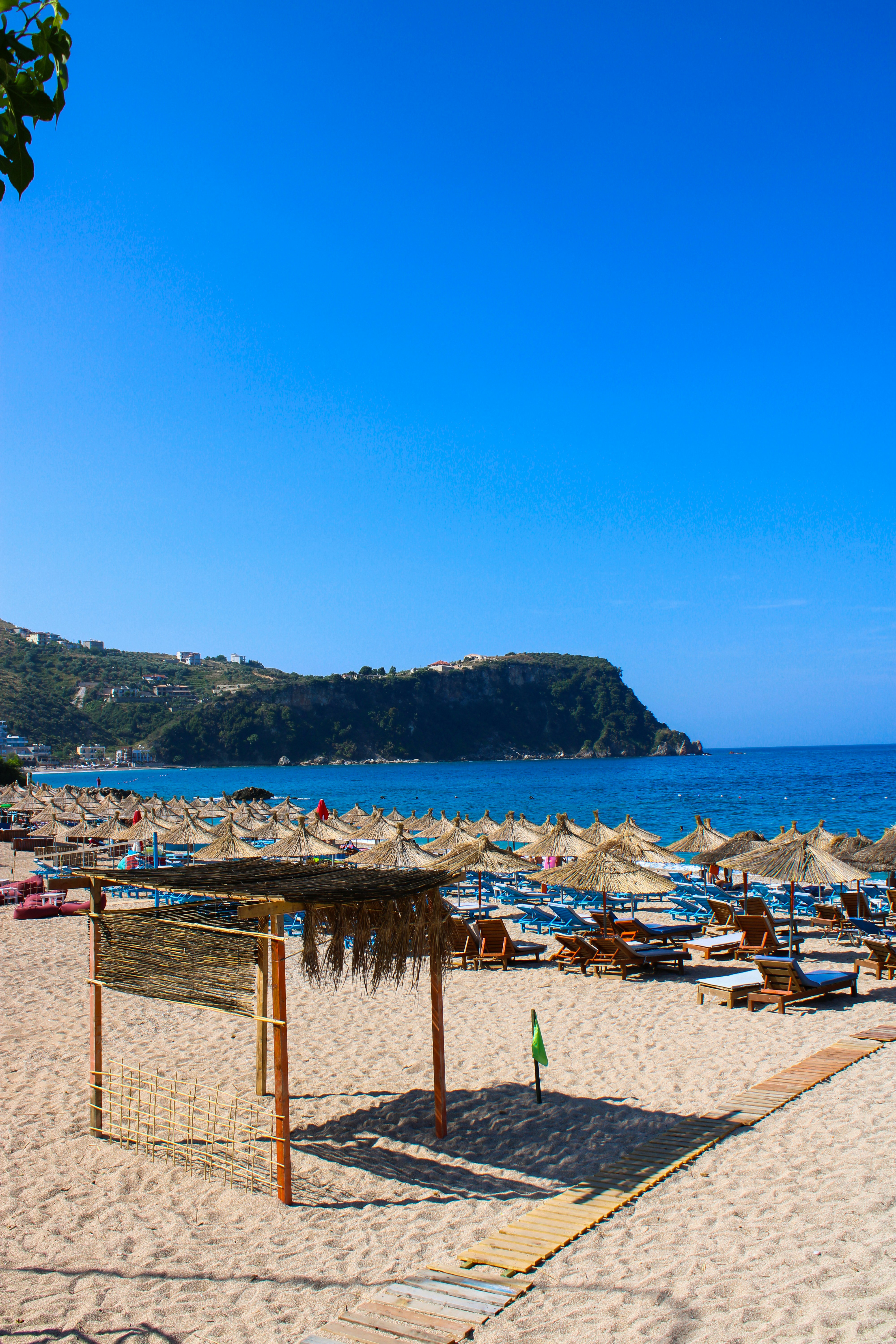 Sunbeds lined up on an Albanian Riviera beach with turquoise water