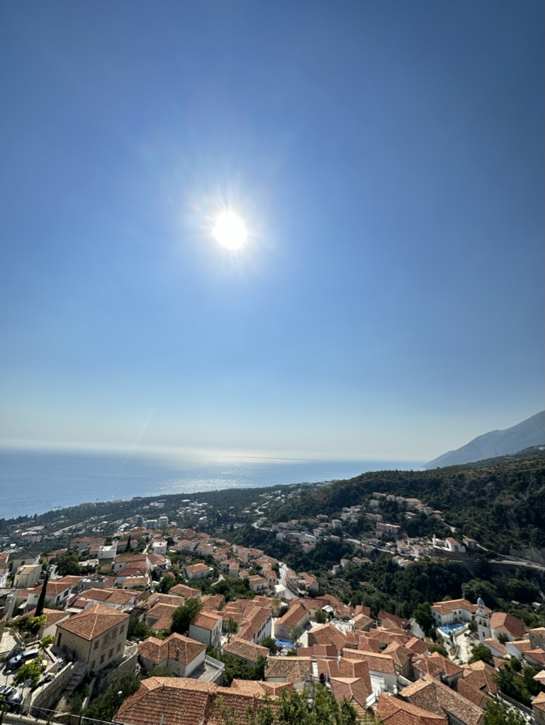 Panoramic view of Vuno village with stone houses set against mountains on Albania's southern coast