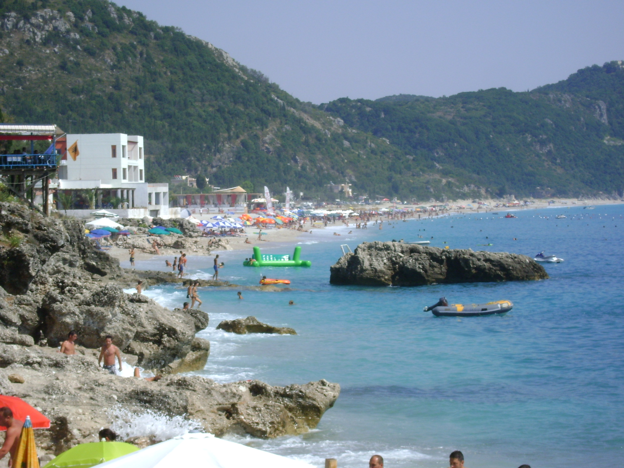 Dhermi Beach with white pebbles and stunning blue Ionian waters backed by mountains