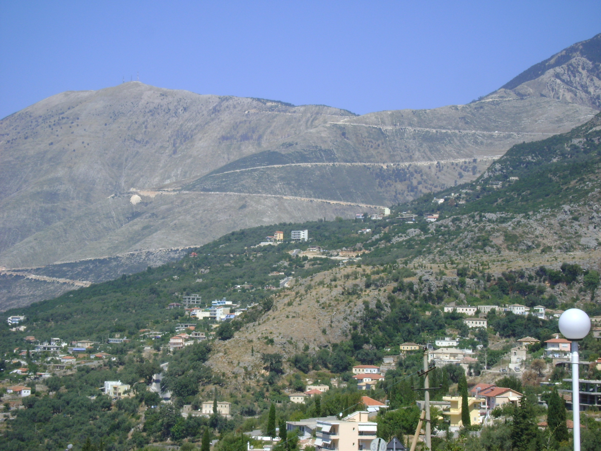 Paraglider soaring above the Albanian Riviera coastline from Llogara Pass