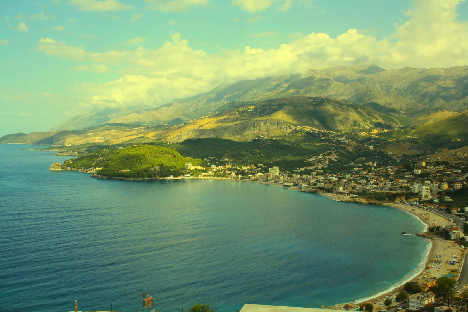 Panoramic view of Himara bay and town in May 2026 — current state of construction, openings and the coastline