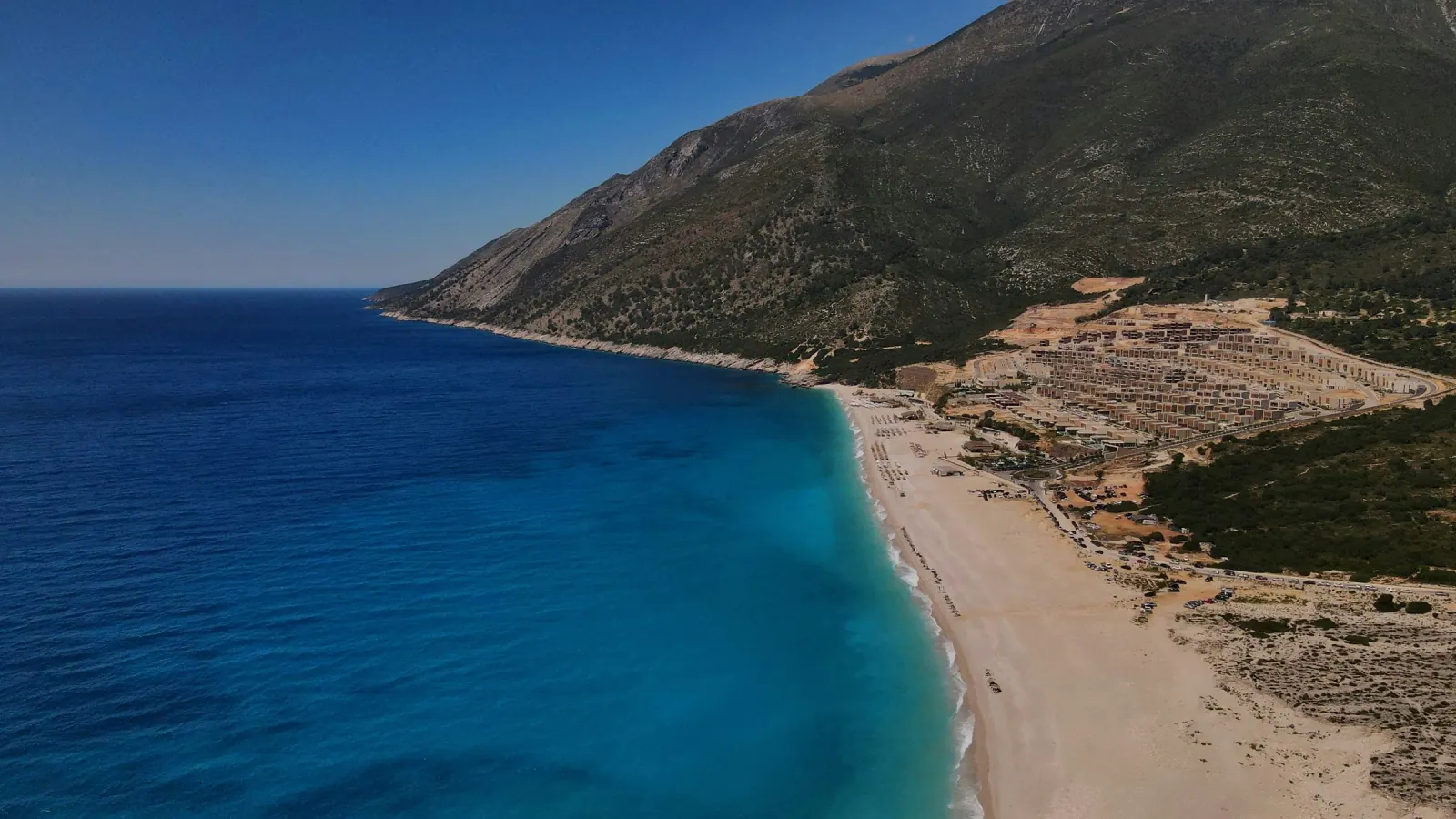 Aerial view of Livadhi Beach coastline showing nearby hotel zone