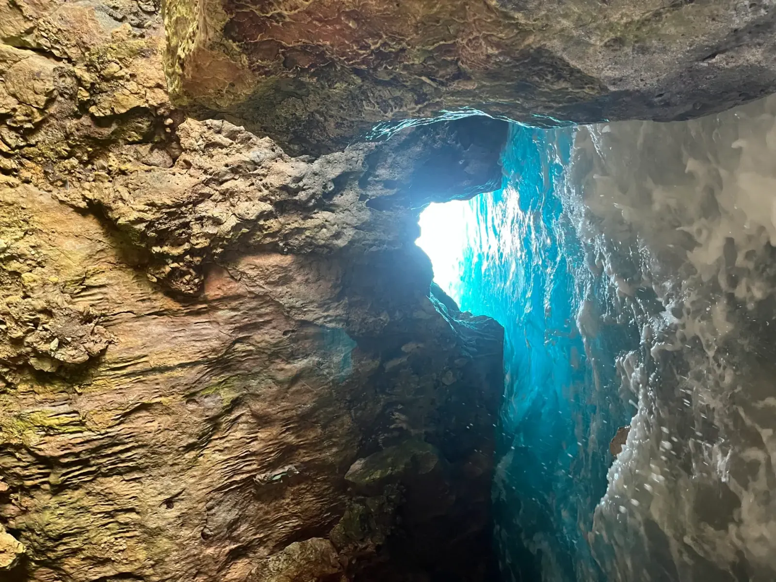 Sea cave on the Albanian Riviera with sunlight piercing the opening, similar to the Blue Cave