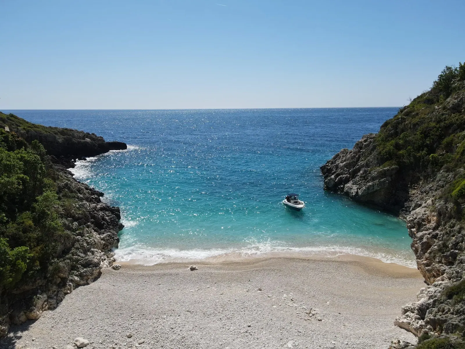 Secluded boat-access cove on the Albanian Riviera, evocative of Couples Bay
