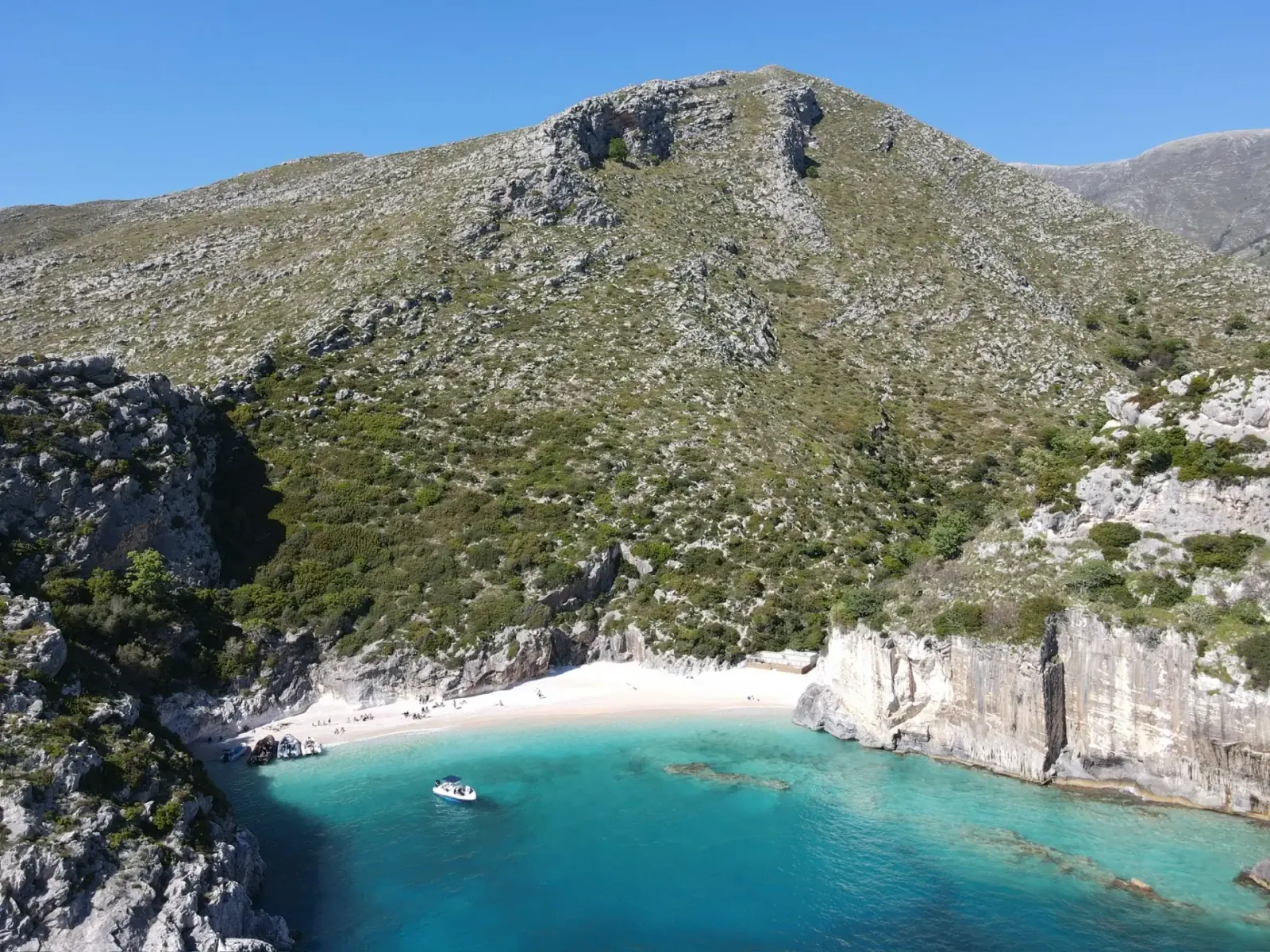 Aerial view of a turquoise bay framed by limestone cliffs near Karaburun, evocative of Crystal Bay