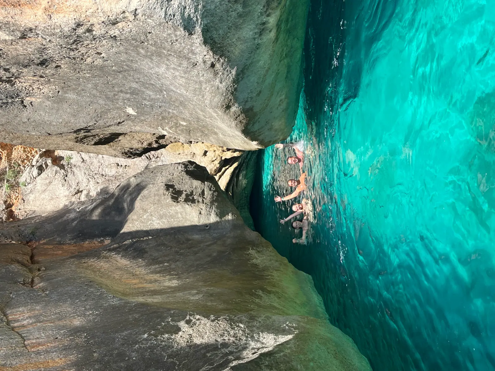 Sea cave entrance with a swimmer for scale, similar to the cave below Saint Theodore Monastery