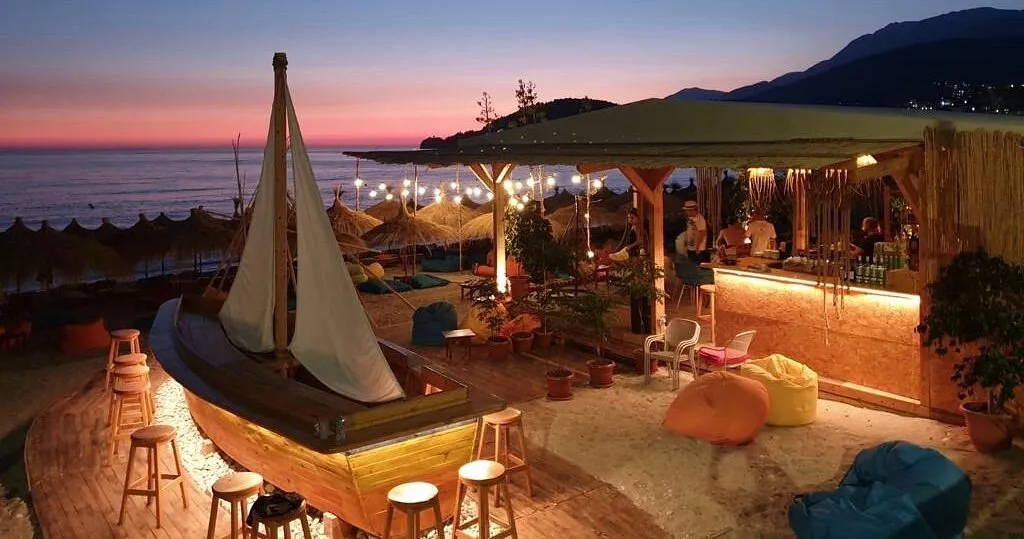 Beanbag seating at Varka Beach Bar with sunset over Potami Beach