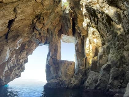 Tour boat anchored in the crystal-clear waters of Grama Bay
