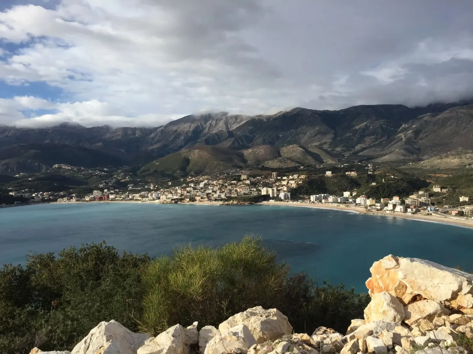 Sfageio Beach with turquoise shallow waters beside the Himara pier