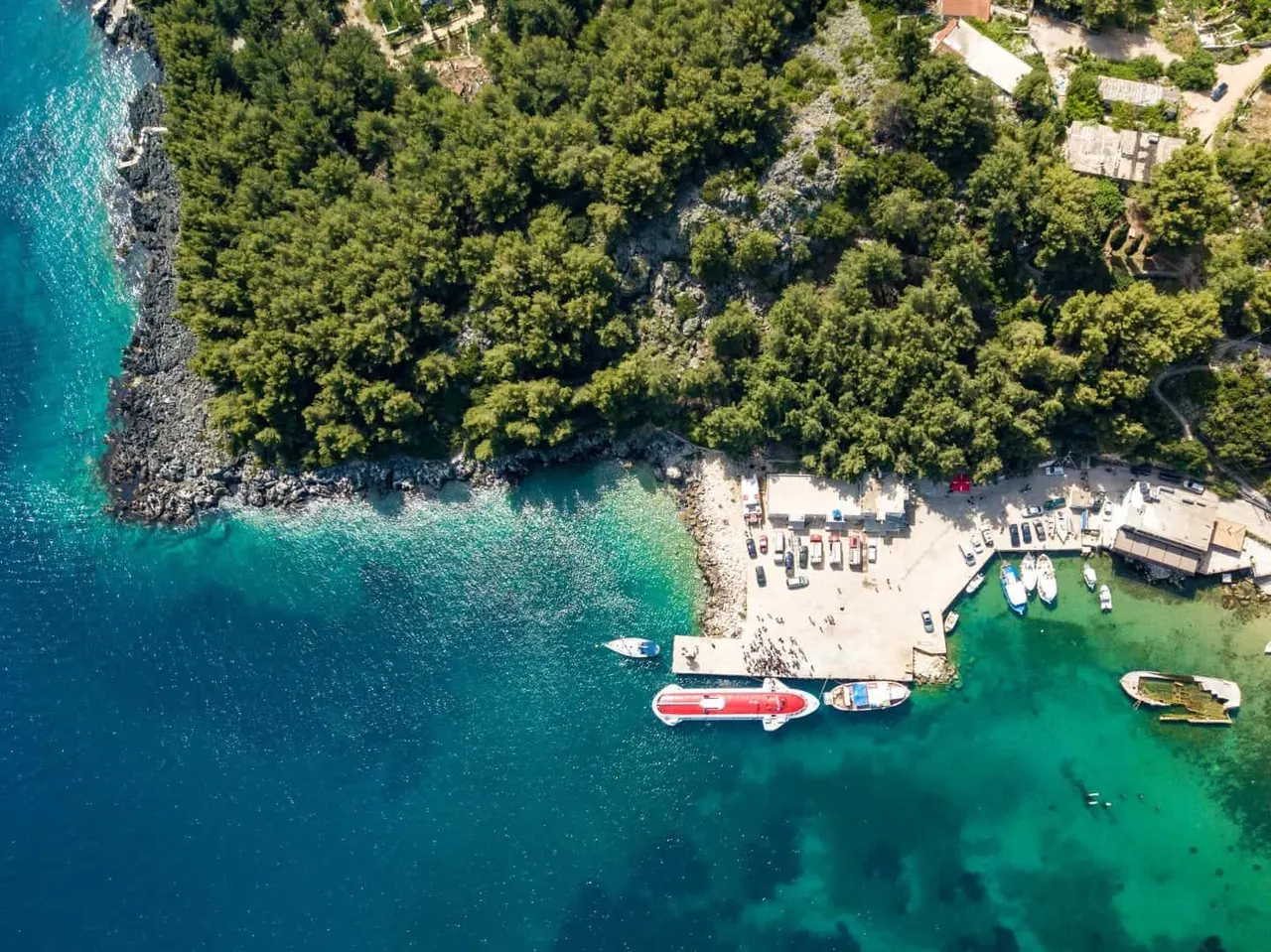 Aerial drone view of a cove and beach club near Spile Beach in Himara