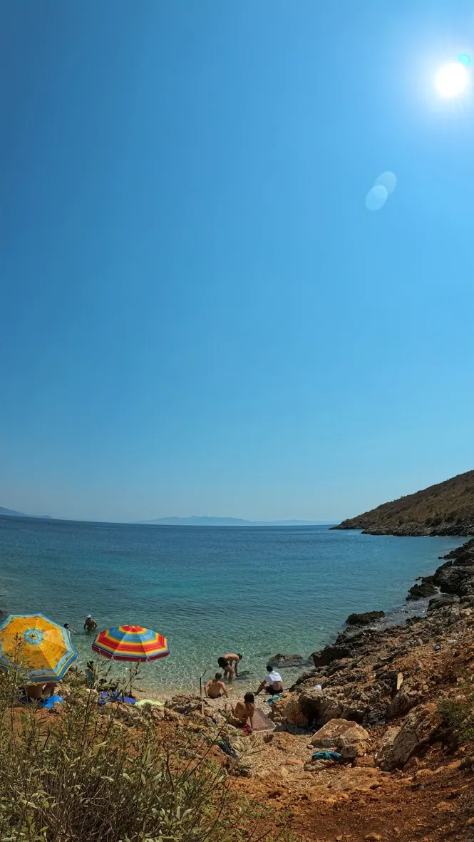 Summer beach umbrellas on Jale Beach near Himara during a sunny June day